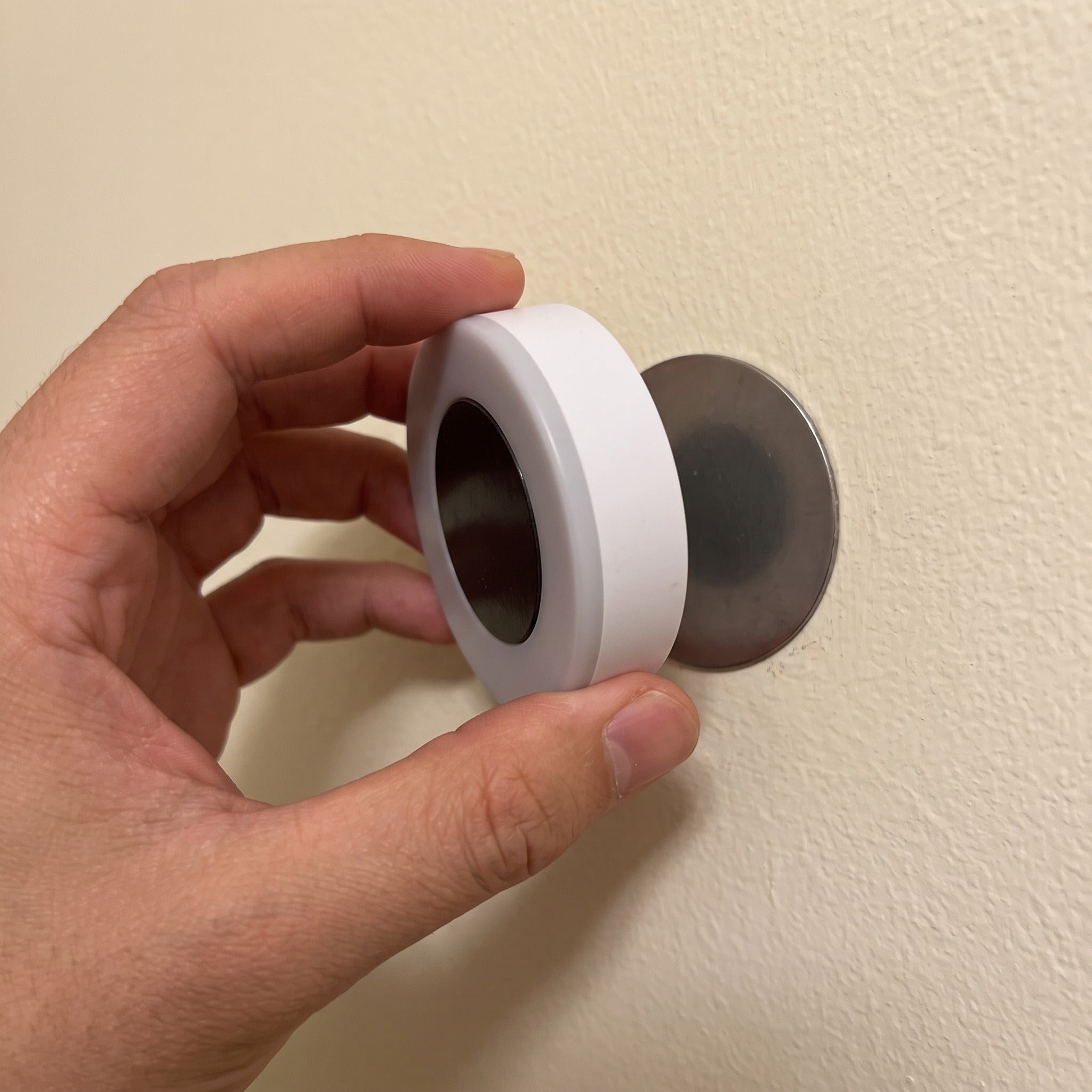 Hand lifting Little Glow off its magnetic plate