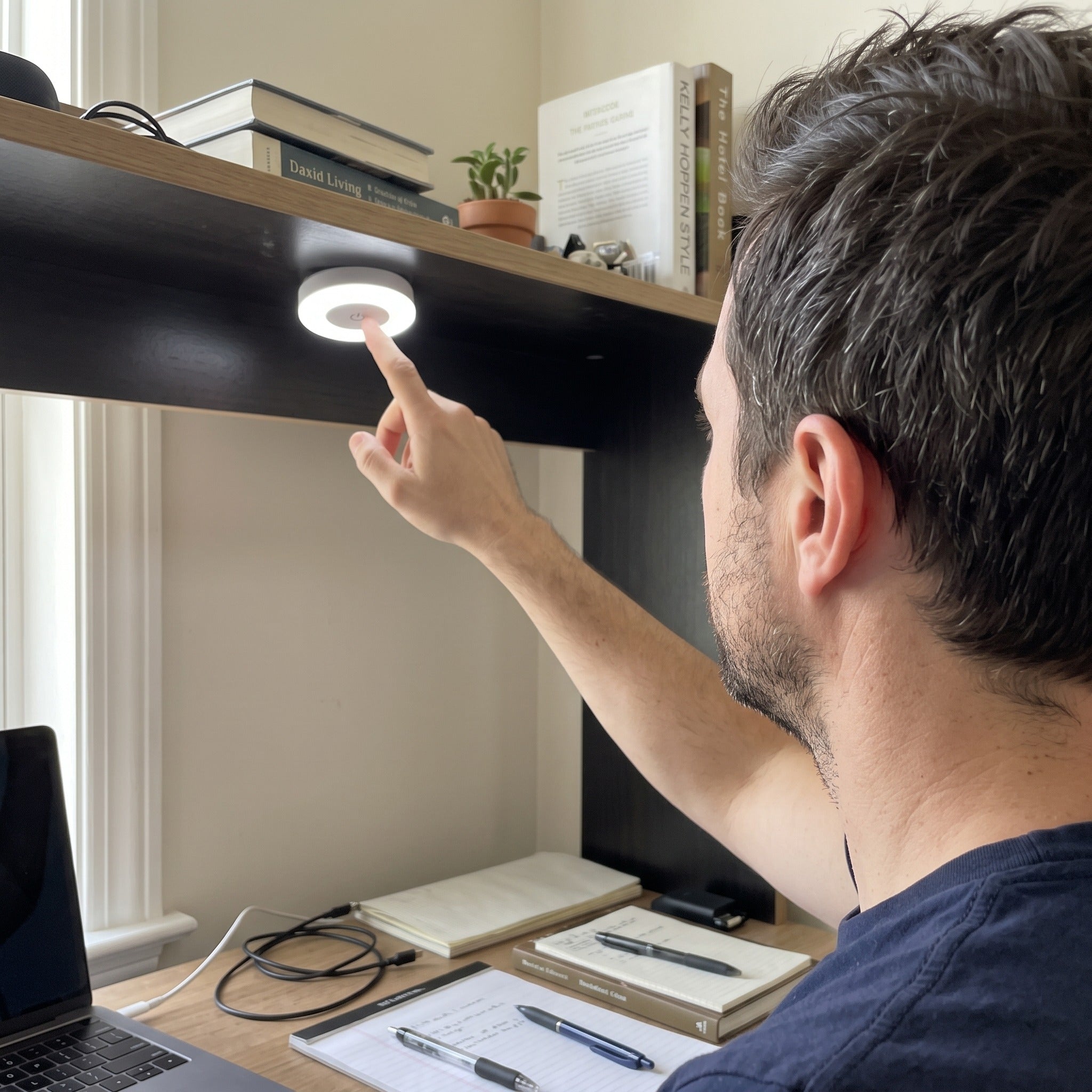Daniel K. showing Little Glow at his desk